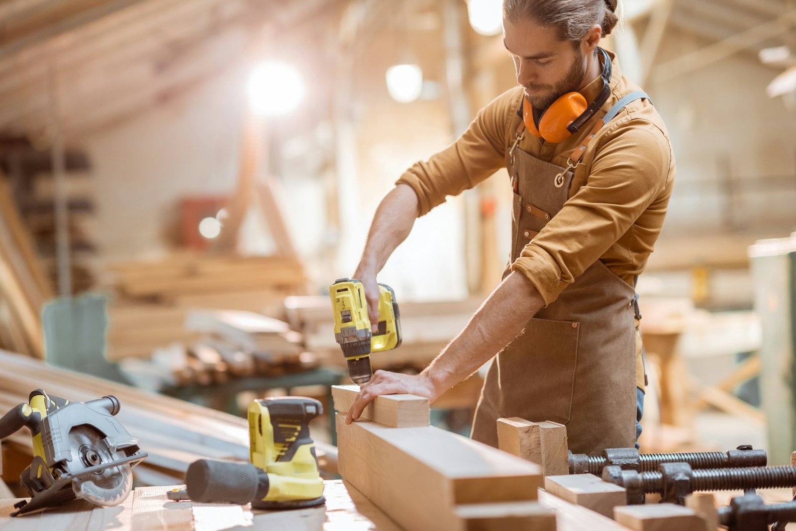 Carpenter working with cordless tools at the workshop